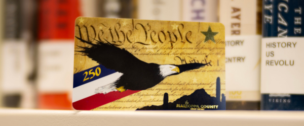Library card with imagery including a bald eagle, text from the Constitution, and a desert landscape