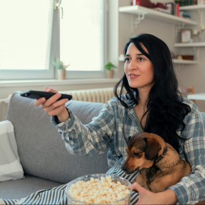 Woman and dog watching TV with popcorn