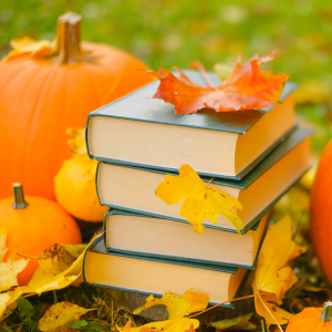 hand marking a calendar with fall items around them