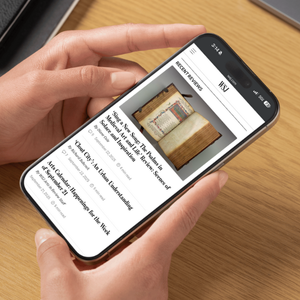 Hands holding a smartphone, open to the Wall Street Journal website